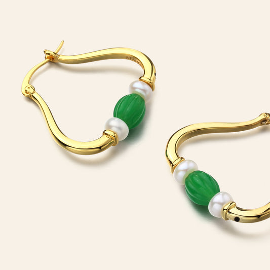 Gold hoop earrings with green and pearl on a light beige background