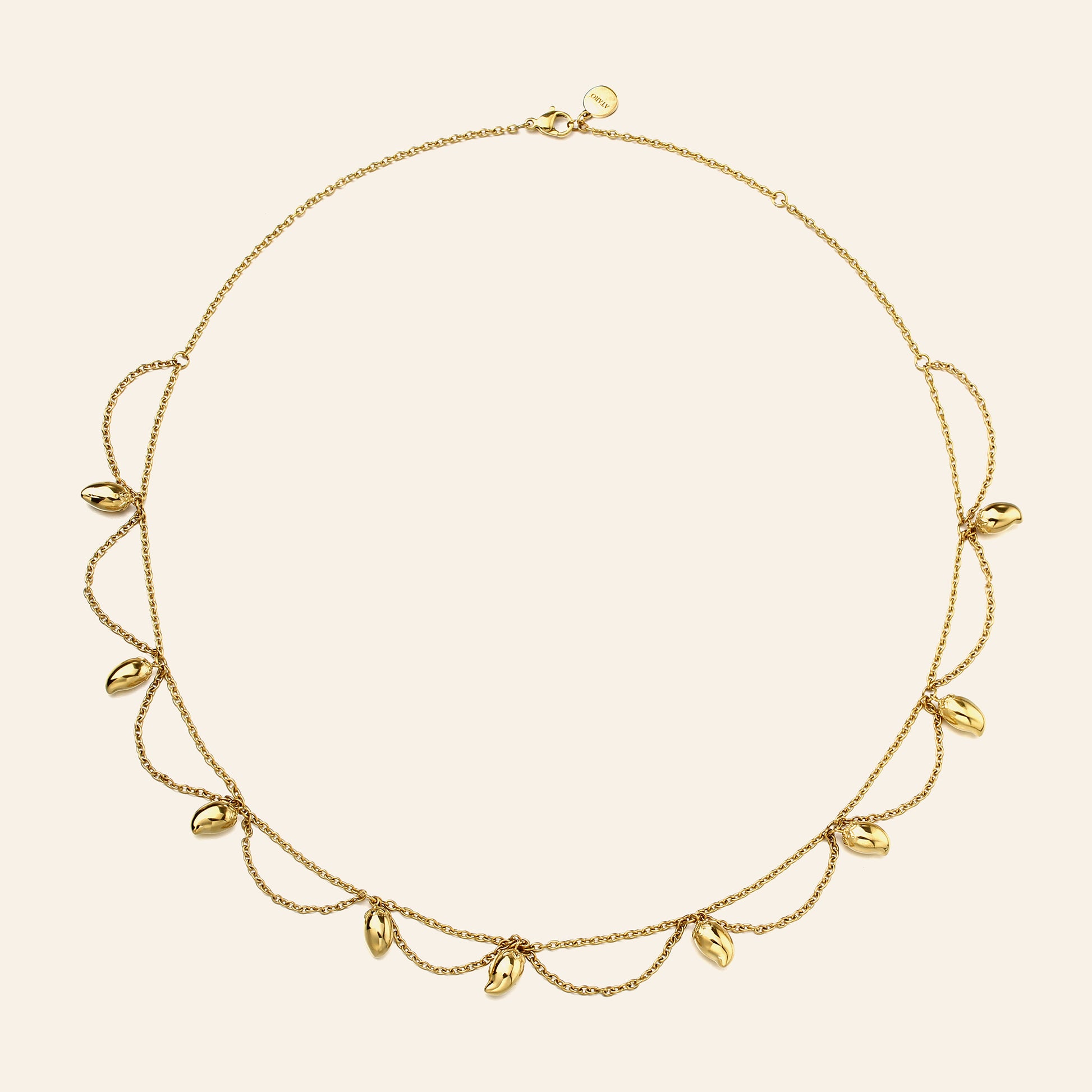 A delicate gold necklace with a fine chain and multiple small mango charms, displayed on a light cream background.