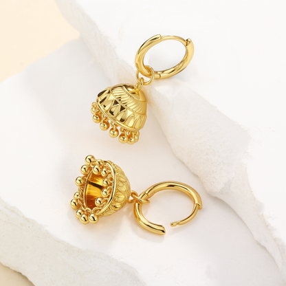 Gold hoop earrings with intricate designs on a white background
