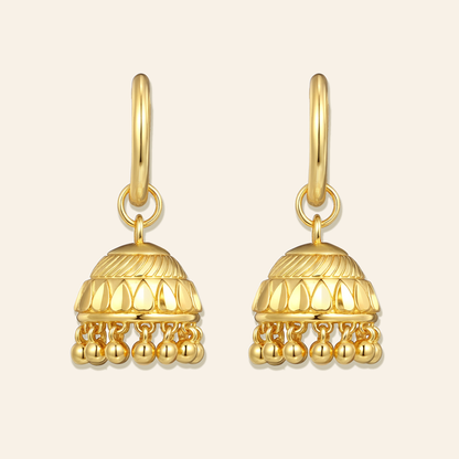 Pair of gold earrings on a beige background