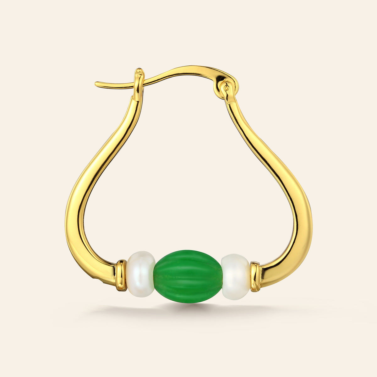 Gold hoop earring with green and  pearl beads on a beige background