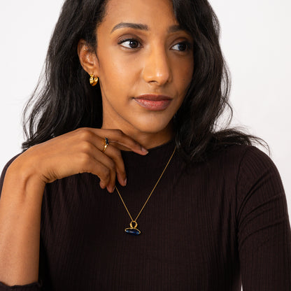 Woman wearing a blue necklace with a white background